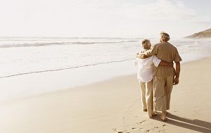 Rear View of a Senior Couple Walking on a Beach With Their Arms Around Each Other